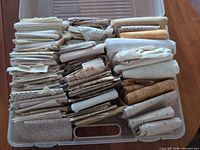 Plastic tub filled with folded neutral quilting cotton pieces