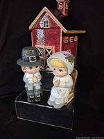 Barn cookie jar with two pilgrim figurines displayed together
