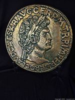 Front view of round Roman coin style plaque