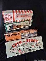 Four boxed items stacked: Wardie-Jay Circus Models, unidentified green caboose kit, Walthers kit, Crib-Derby game