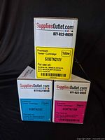 Front view showing three individual SuppliesOutlet toner boxes (yellow, cyan, magenta)