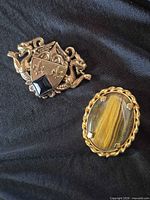 Both brooches together for size and style comparison
