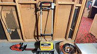 Full view of snow thrower, hedge trimmer and cords