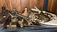 All brass and wood decorative items grouped on shelf
