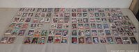 Wide shot of roughly 110 loose baseball cards laid out on a table