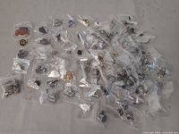 Group of individually bagged lapel pins spread on surface