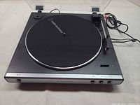Top view of turntable with dust cover open showing platter, tonearm and controls