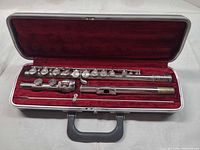 Open case showing complete Bundy flute disassembled and cleaning rod