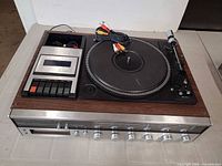 Top view of stereo console showing turntable, cassette deck and coiled RCA cables