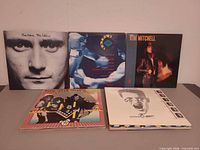 Overview of six album covers, including Phil Collins, Kim Mitchell, KISS and others