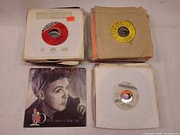 Four stacks of 7-inch singles, visible labels Columbia, Sun/Victor, Paul McCartney picture sleeve