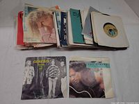 Stack of 7" singles with Genesis and John Mellencamp sleeves visible