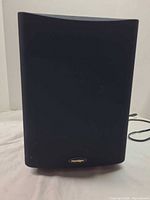 Front view of black Paradigm subwoofer with grille and logo