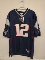 Front view showing number 12, Patriots sleeve logos, tags attached