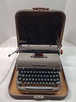 Typewriter seated inside open carrying case