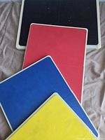 Four color-coded rebreakable boards stacked, showing surfaces and white frames