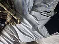 Overall view of shirts and part of coat on bed