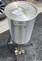 Pot with lid on burner stand showing regulator hose attached
