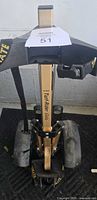 Front view of folded Tuf Mate Turf-Rider Gold pull cart showing handle, frame branding, wheels