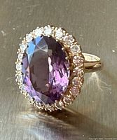 Front view showing oval amethyst and diamond halo ring