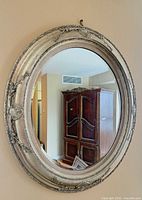 Front view of oval silver antique-style mirror on wall