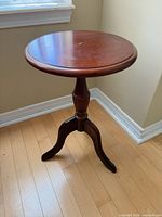 Full view of table showing round top and tripod base