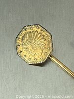 Front view of octagonal coin head on stick pin showing Indian chief design and star border