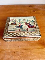 Top view showing painted horseback riding scene and geometric inlay border