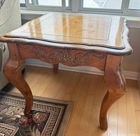 Square solid wood side table beside sofa showing top and leg design