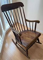 Left angle view of full rocking chair showing spindle back, curved arms and rockers