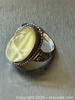 Angled top view of sterling ring with yellow oval cabochon