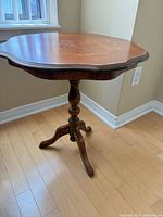 Full view of side table showing shape and pedestal base