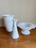 Group shot of three milk glass items: large vase, bud vase, compote