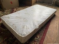 Full view of crib mattress showing size, pattern, and overall condition