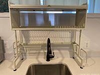 Full front view of rack over sink showing top cabinet door, plate rack and attachments