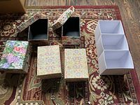 Group shot of floral boxes, white organizer, rug background