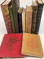 Group shot of all ten hardcover books standing and two lying flat