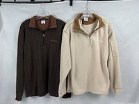 Both Columbia pullovers hanging side by side