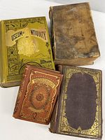 Group shot of four antique books showing covers and spines