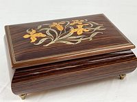 Closed music box showing front and brass feet