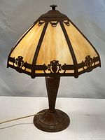 Full view of lamp showing slag glass shade, metal base, power cord