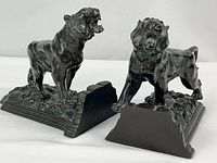 Two cast metal lion bookends side by side
