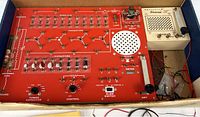 Overview of red console board and ivory speaker inside original box