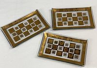 Three gold and white bent glass trays overview