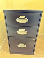 Front view of black 3-drawer filing cabinet showing handles and lock