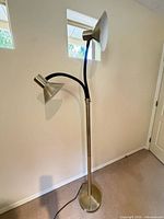 Full view of floor lamp showing base, pole, two heads and cord