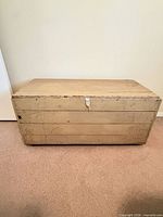Front view of distressed ivory-green wooden chest