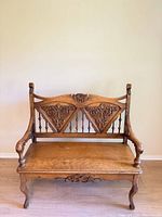 full front view of carved oak settee showing overall design and medium brown finish
