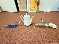Group shot of coffee pot, blue art glass dish, metal holder, and small floral dish