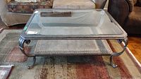 Full view of coffee table front showing glass top and lower shelf